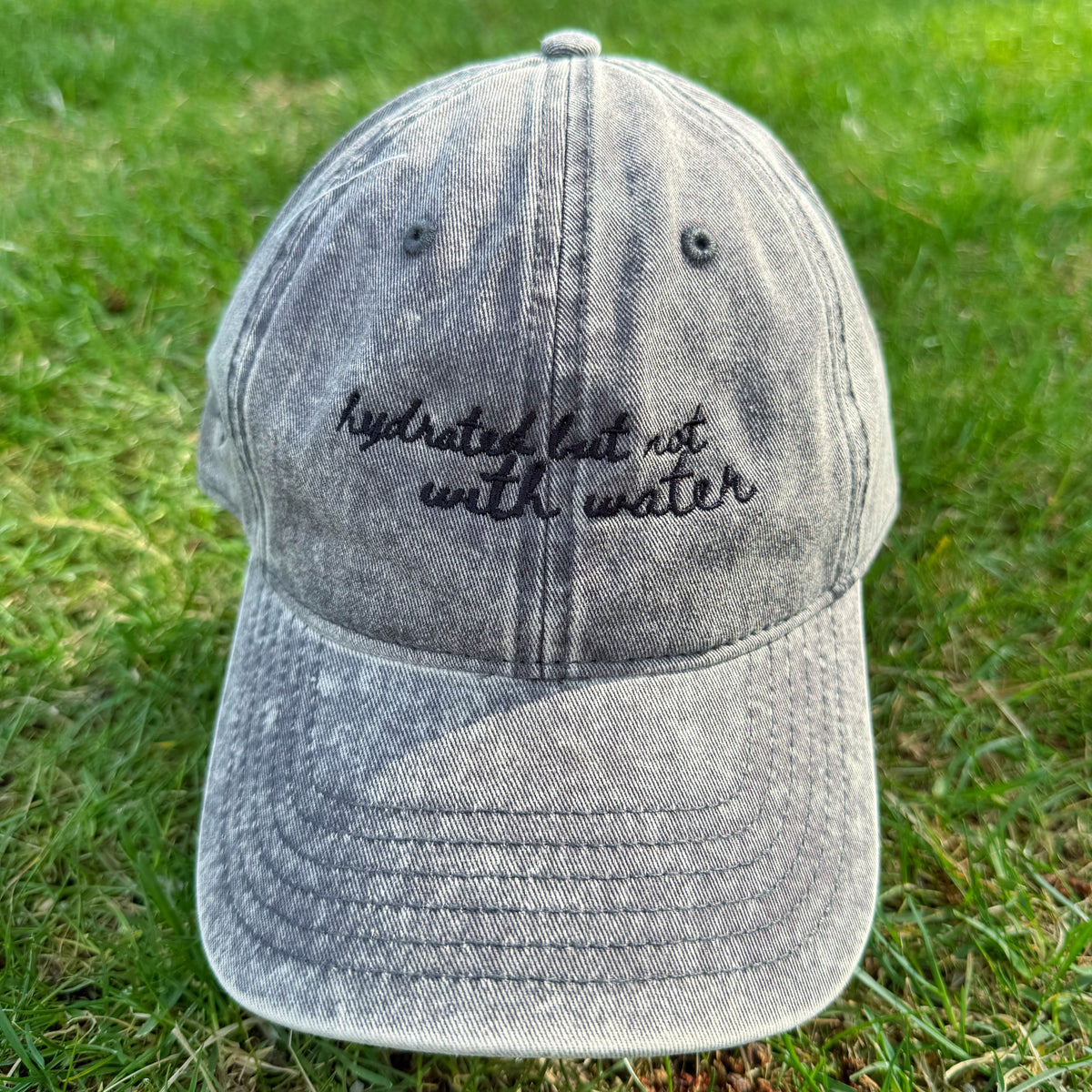 "Hydrated but not with water" - Funny Travel Hat for Beach Lovers-  on grass